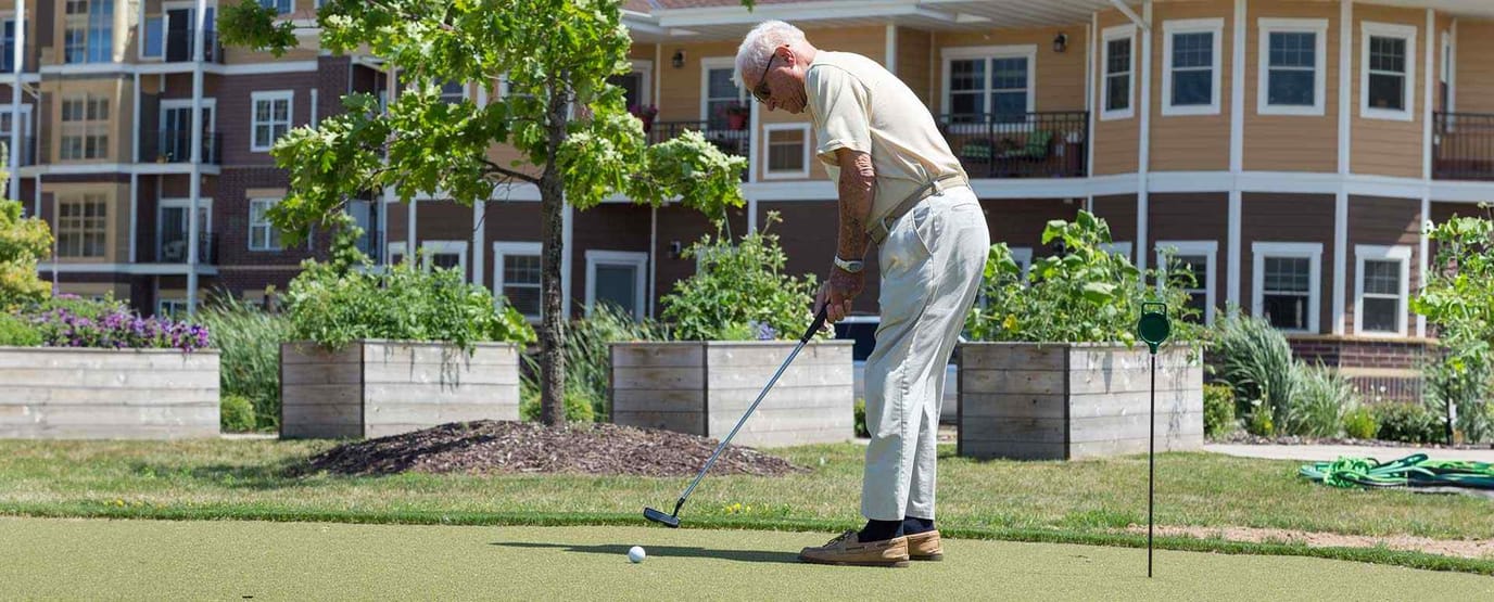 Resident playing golf in an outdoor green space