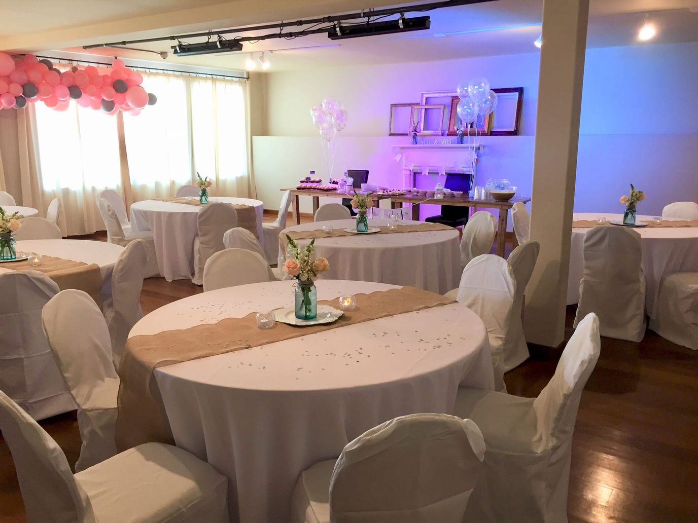 Decorated interior with tables set for an event.