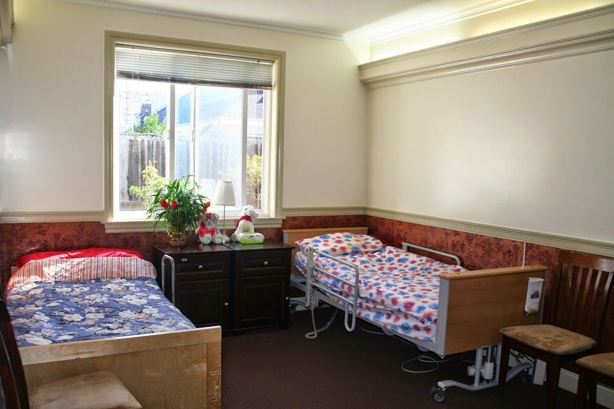 Resident room with two beds and a plant.