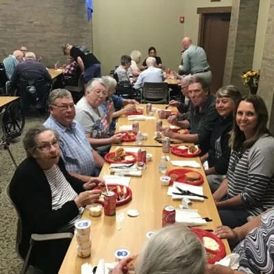 Residents enjoying a meal together in dining area.