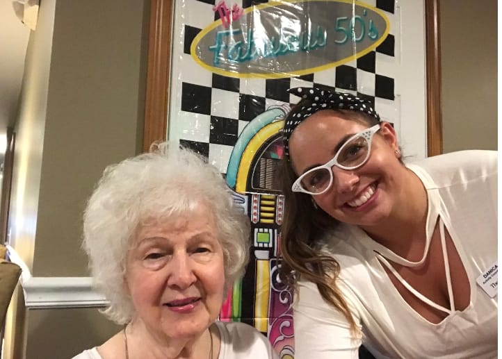 A resident and staff member smiling together.