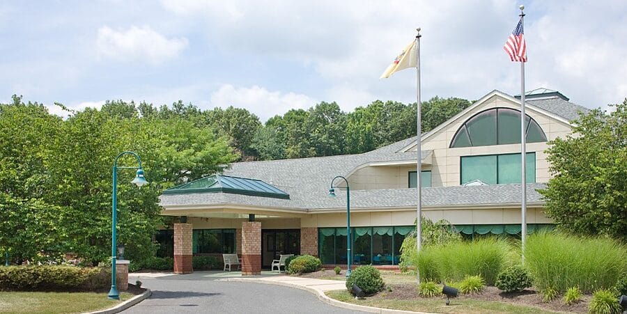 Exterior view of Cranbury Center with flags and landscaping