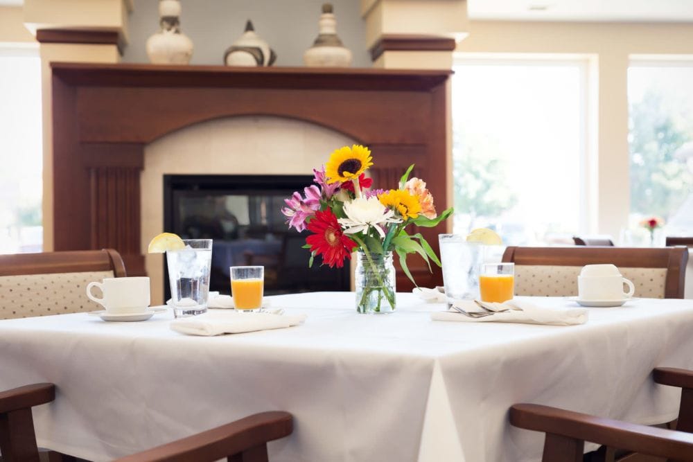 Dining table with flowers and beverages in a common area