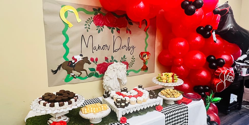 Decorated table with a cake and snacks for a Manor Derby event