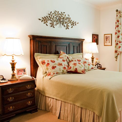 Cozy bedroom with floral decor and bedside lamps.