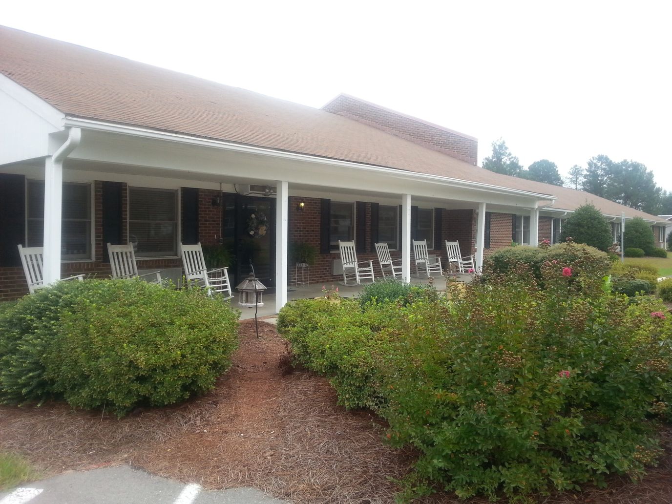 Exterior view of an assisted living facility with rocking chairs