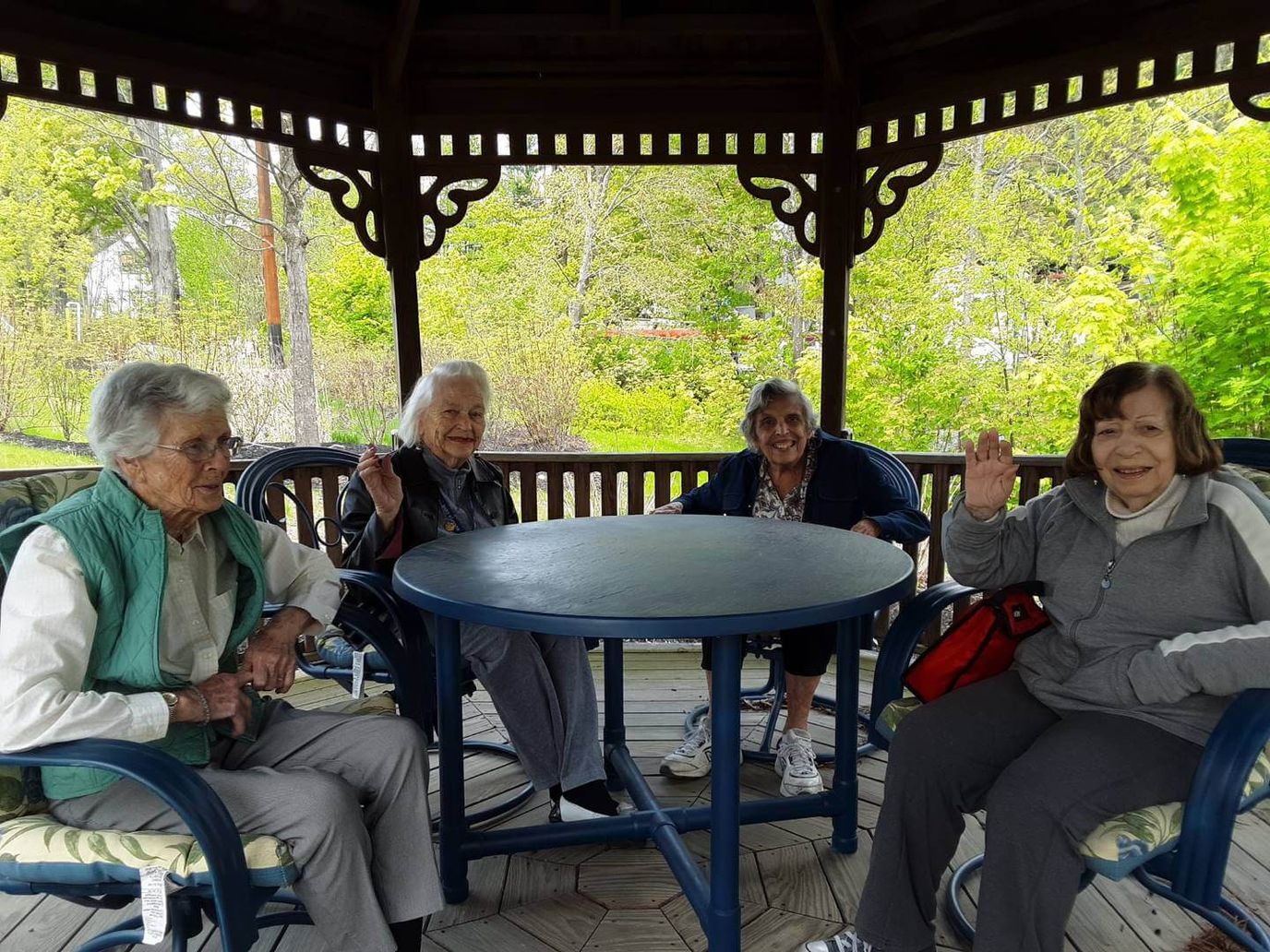 Four residents waving in a gazebo