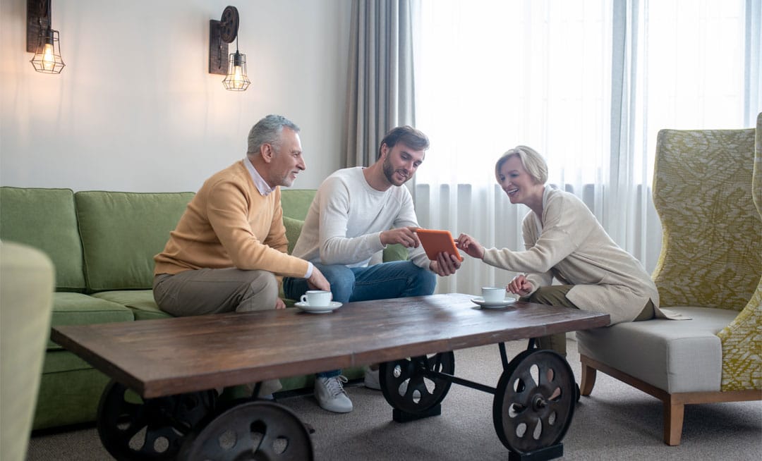 Residents engaging with a tablet in a cozy common area