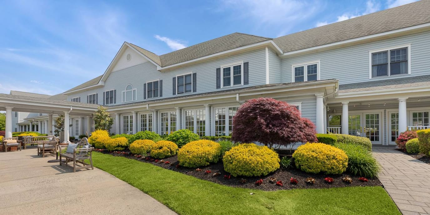 Exterior view of a senior living facility with landscaped gardens
