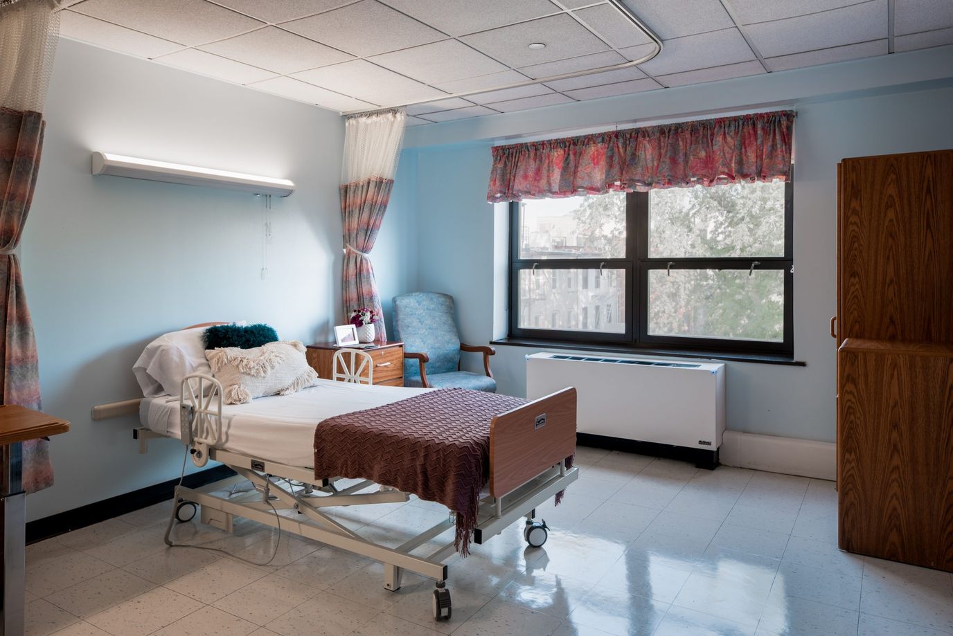 A prepared resident room with hospital bed and chair