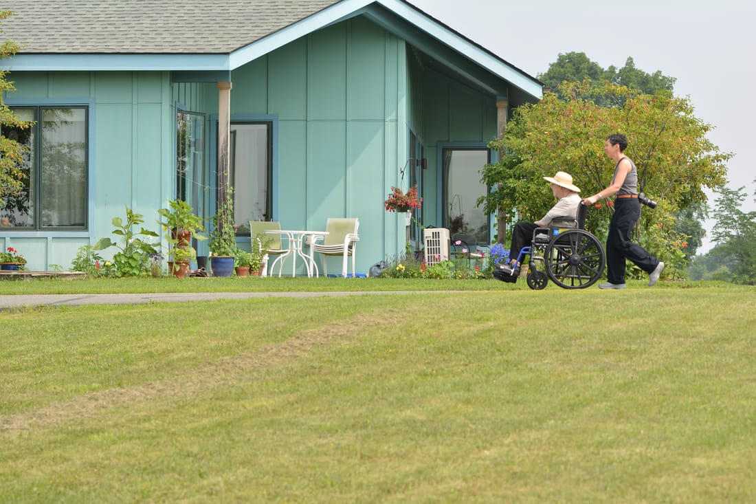 Staff member assisting a resident in a wheelchair outdoors