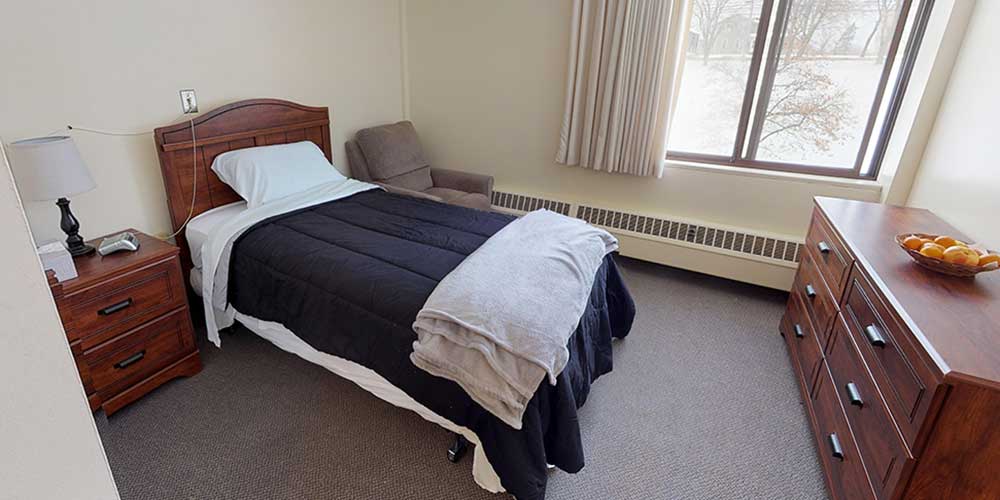 Cozy bedroom with a bed, dresser, and chair