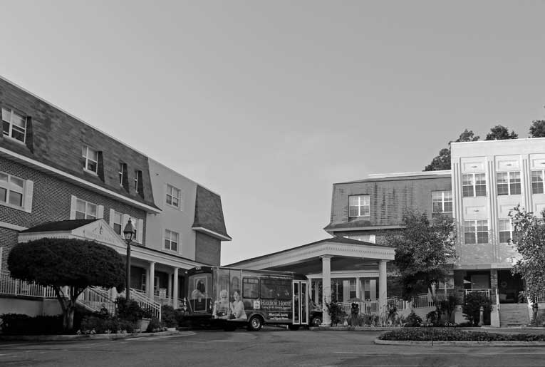 Entrance view of Oyster Bay Manor with facility van