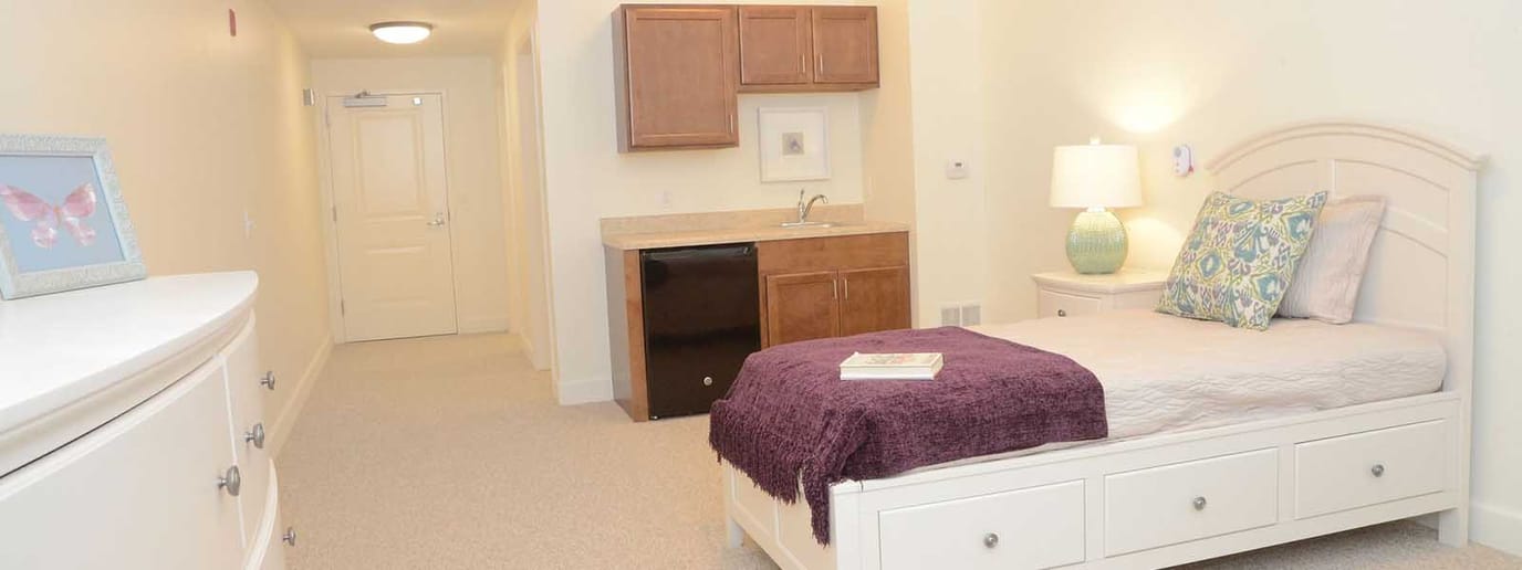 A private resident room featuring a bed and kitchenette