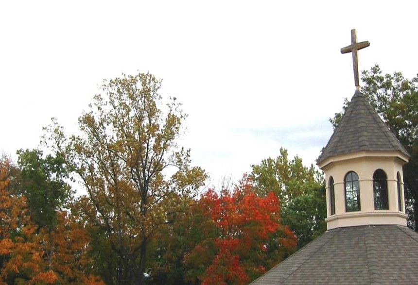 Exterior view of a building with cross and trees