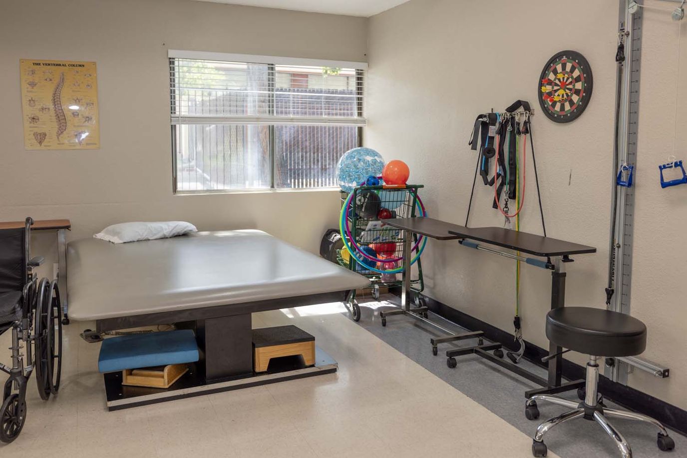Physical therapy room with equipment and a treatment table
