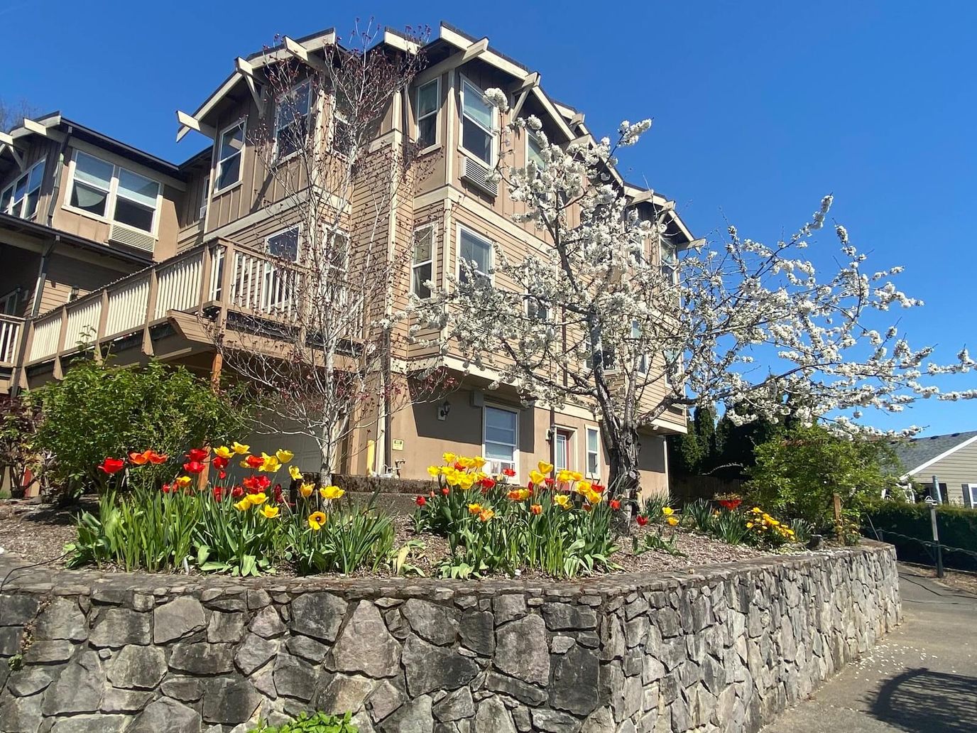 Exterior view of a senior living facility with flower beds