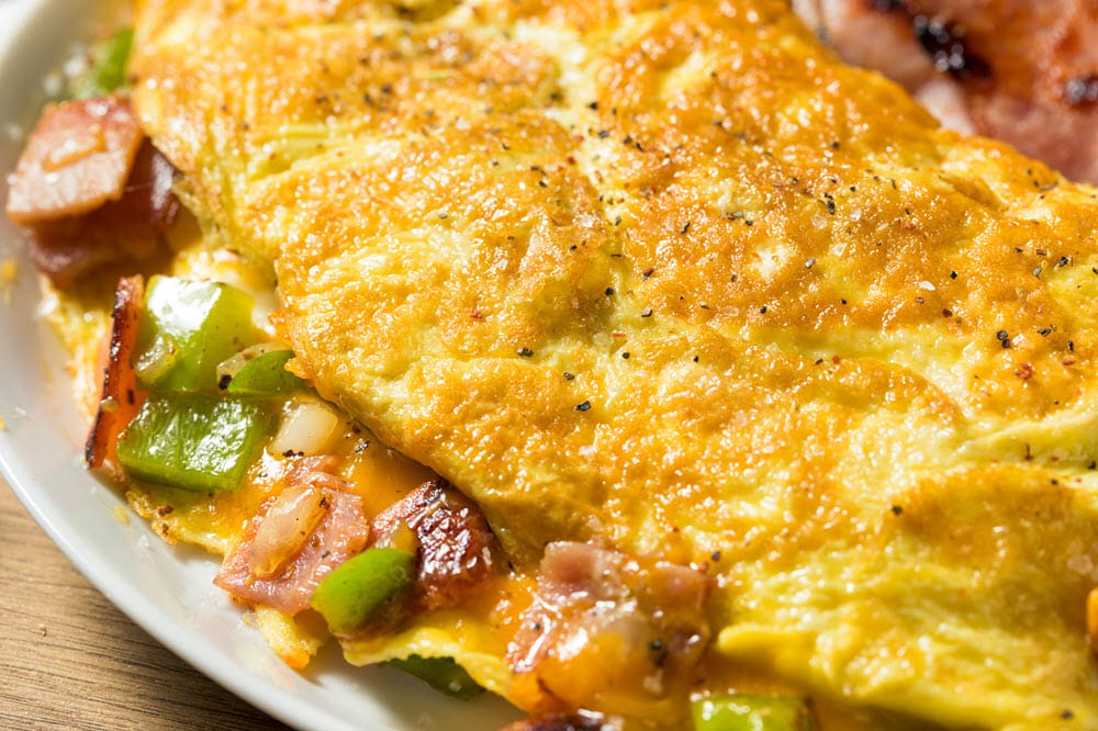 Delicious omelette with vegetables and bacon.