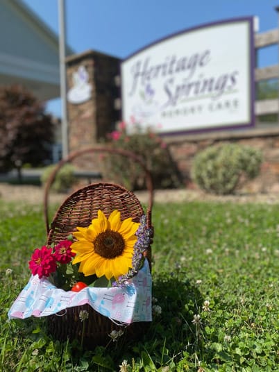 Flower basket in front of Heritage Springs Memory Care sign.