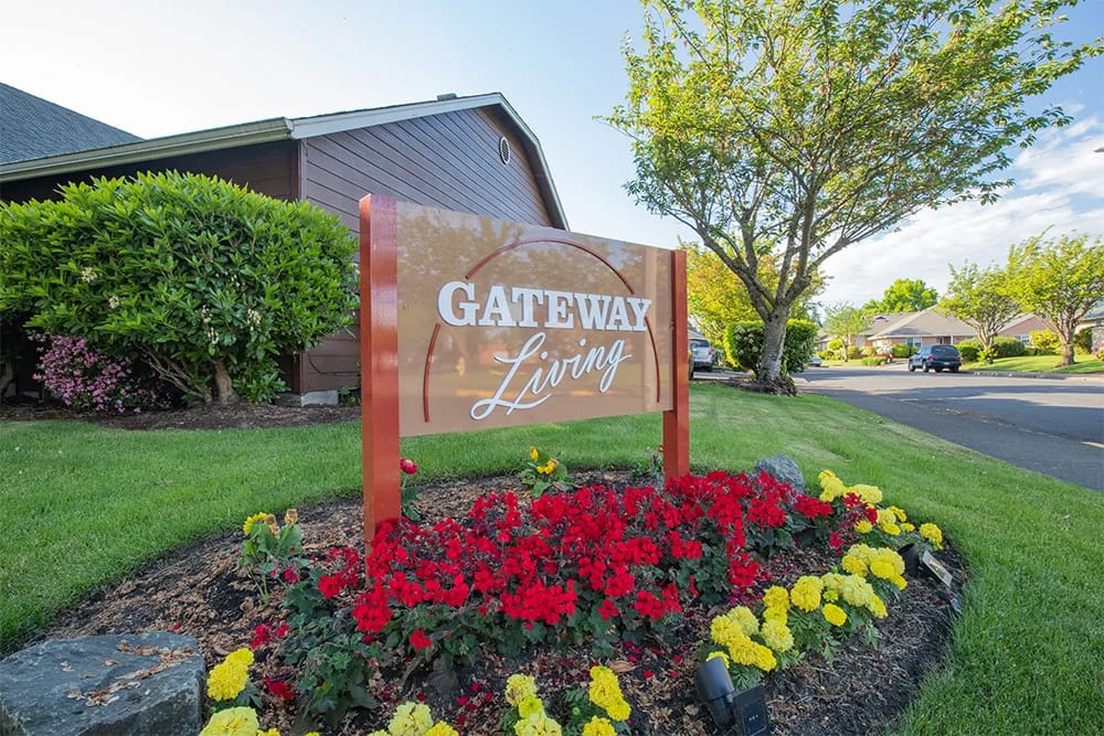 Exterior sign of Gateway Living with flowers