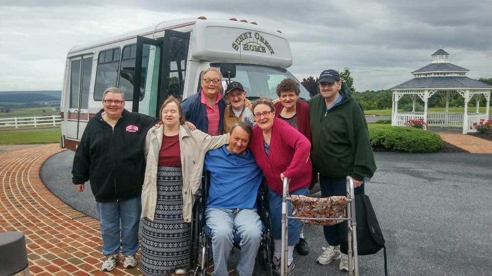 Residents and staff outside a shuttle bus at Sunny Crest Home
