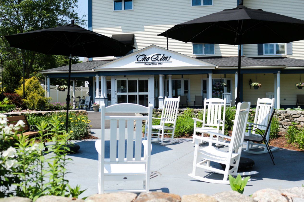 Outdoor seating area with rocking chairs near the entrance