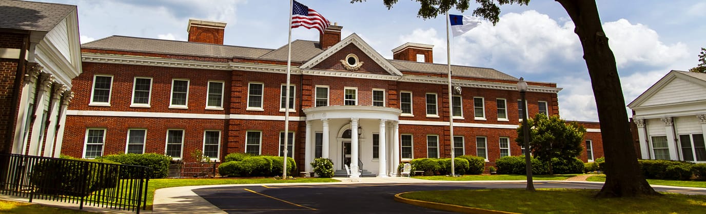 Exterior view of Shepherds Care Center building with flags