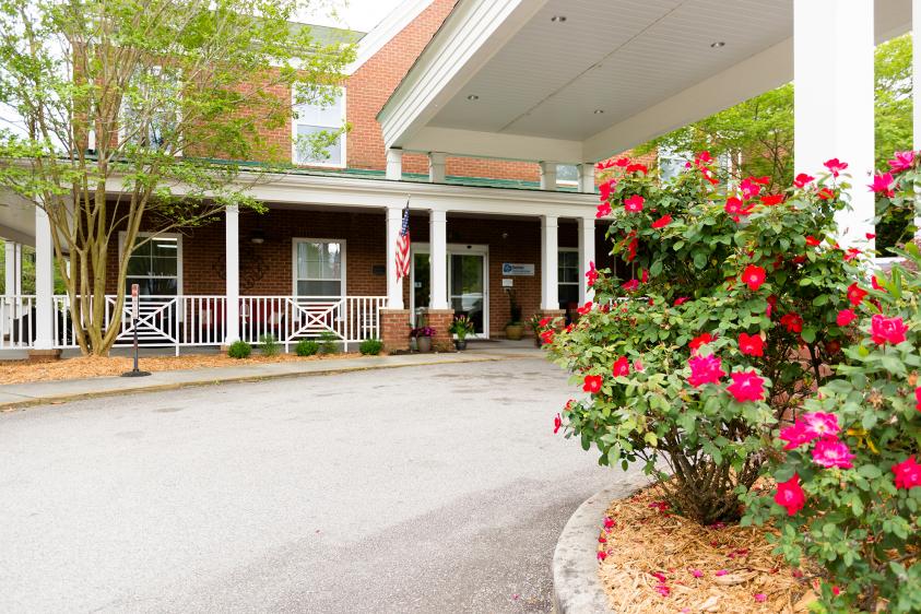 Entrance of a senior living facility with flower beds