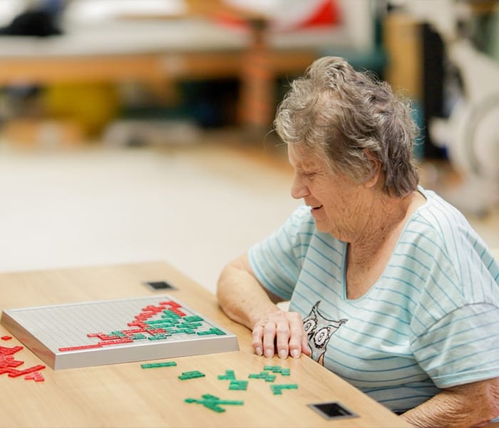 Resident playing a game at a communal table