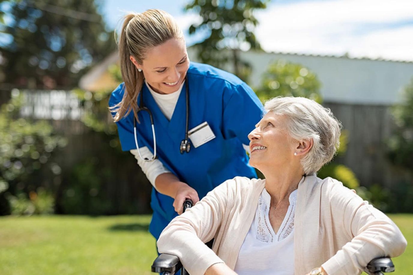 Nurse assisting a senior woman in a garden