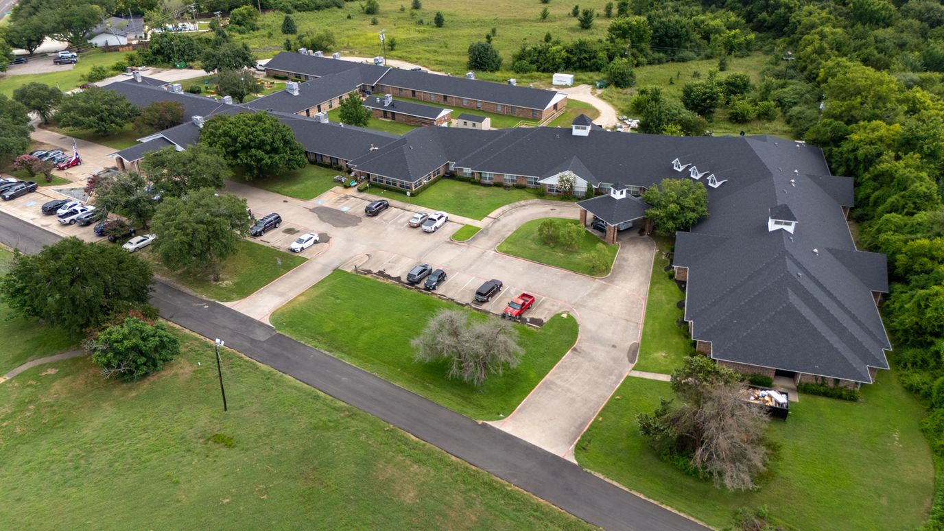 Aerial view of Crestwood Assisted Living facility with parking and gardens
