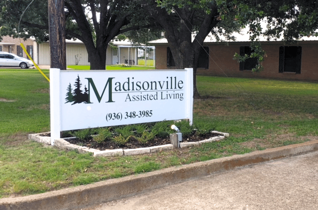 Sign for Madisonville Assisted Living with landscaping