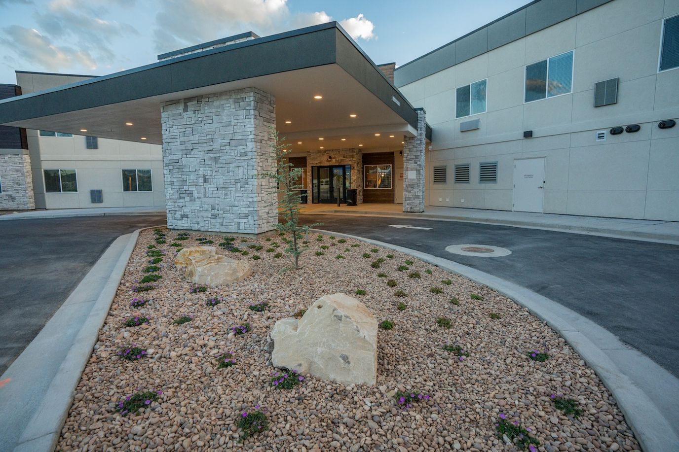 Entrance of a modern senior living facility with landscaped garden
