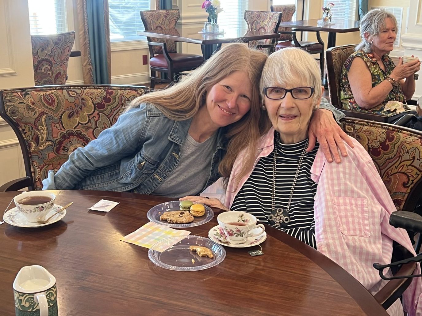 A resident enjoying tea with a guest in a common area