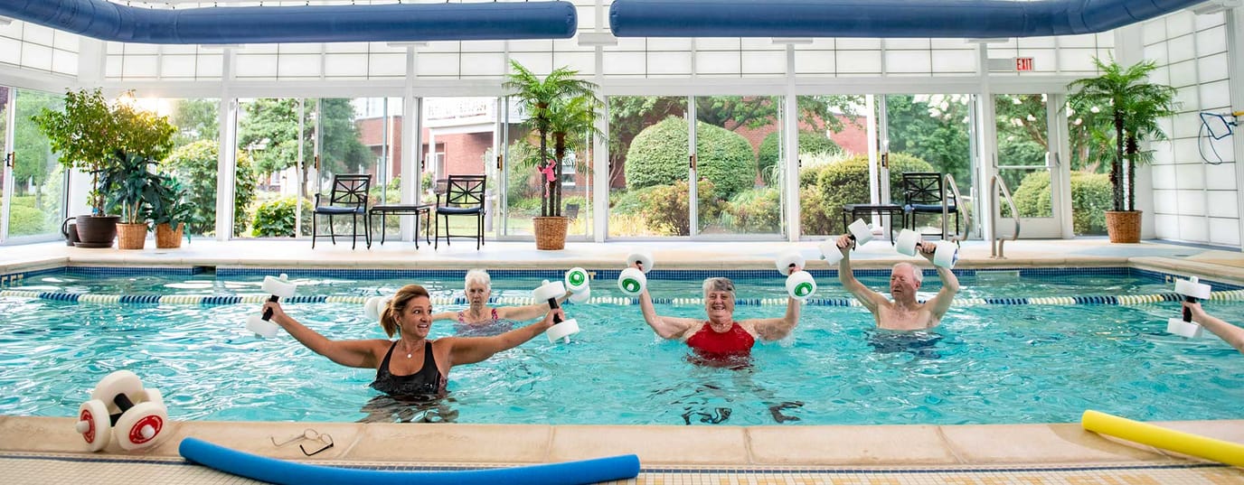 Residents participating in water aerobics class in a pool