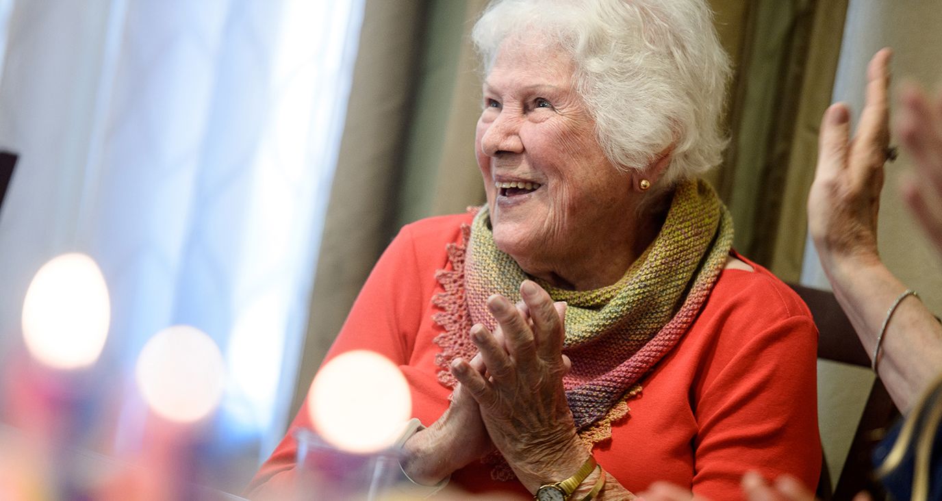 Senior resident clapping and enjoying celebration.