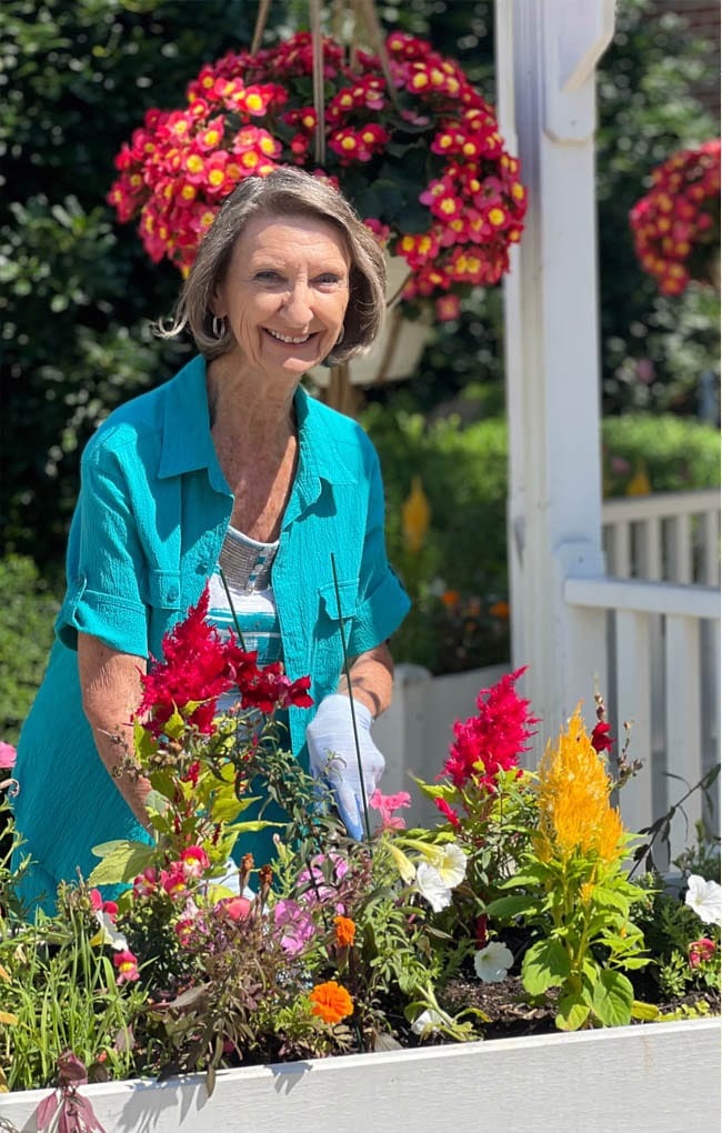 A resident gardening in a vibrant outdoor space
