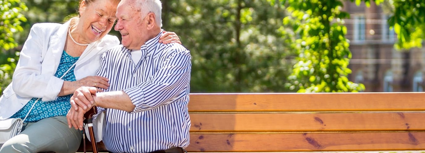 Elderly couple enjoying time on a park bench.