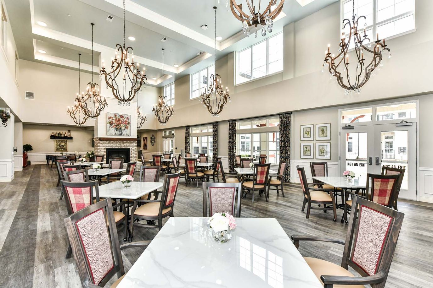 Bright dining room with elegant chandeliers and large windows