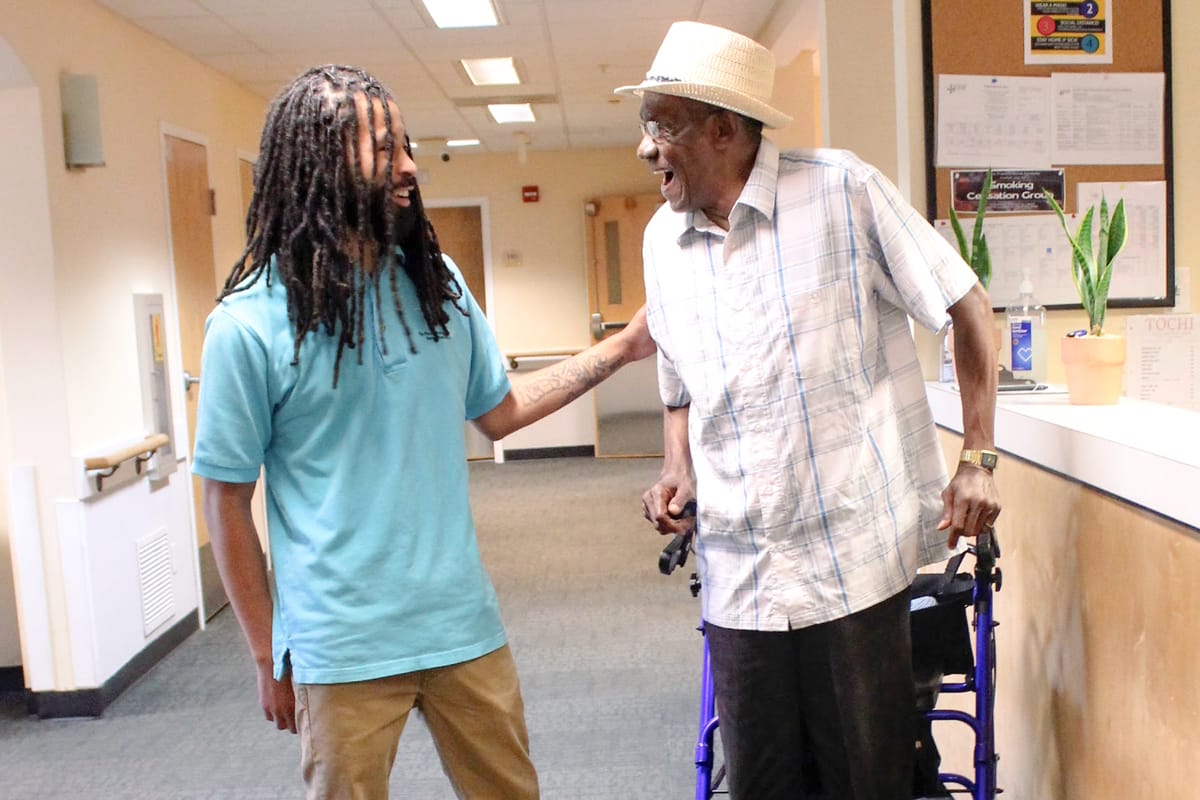 Staff assisting a resident in a hallway