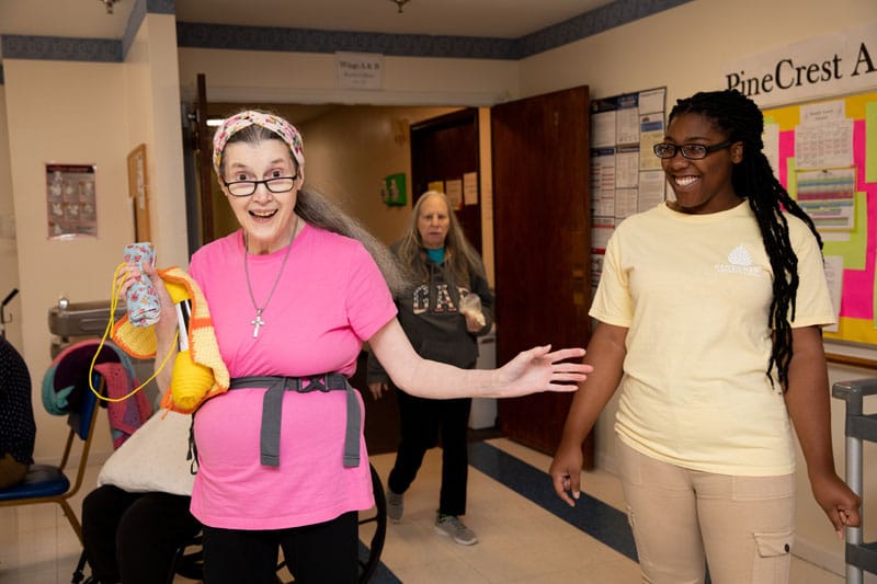 Residents and staff engaging in a lively interaction inside the facility