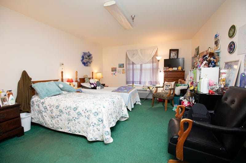 Cozy resident bedroom with floral bedding and personal decor.