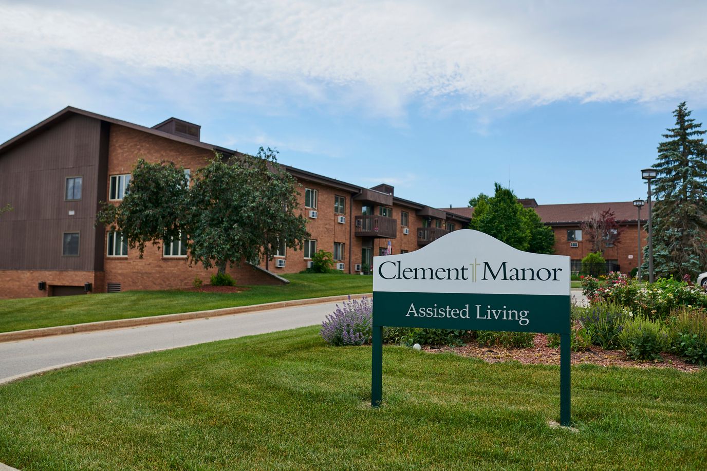 Exterior of Clement Manor with sign and landscaping