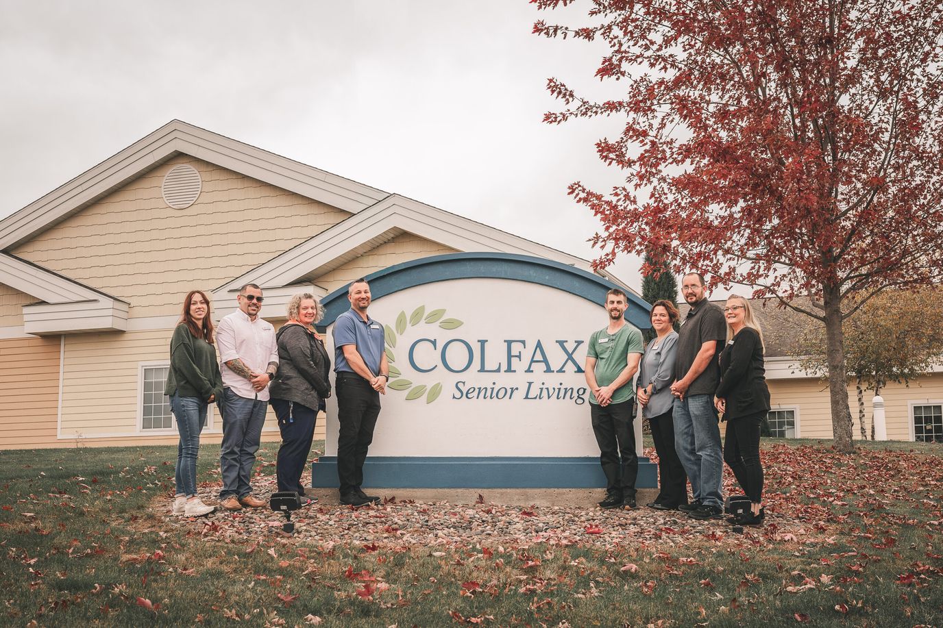 Staff posing in front of Colfax Senior Living sign