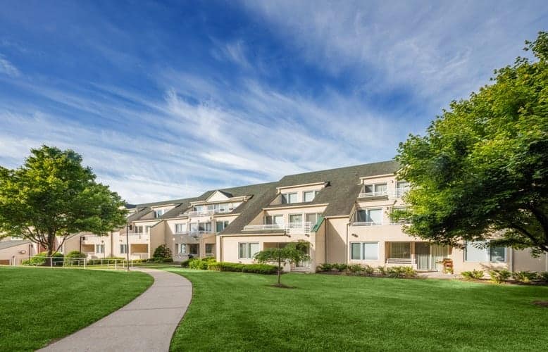 Exterior view of a senior living facility surrounded by greenery