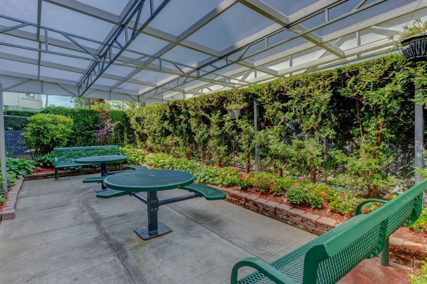 Outdoor seating area with tables and greenery