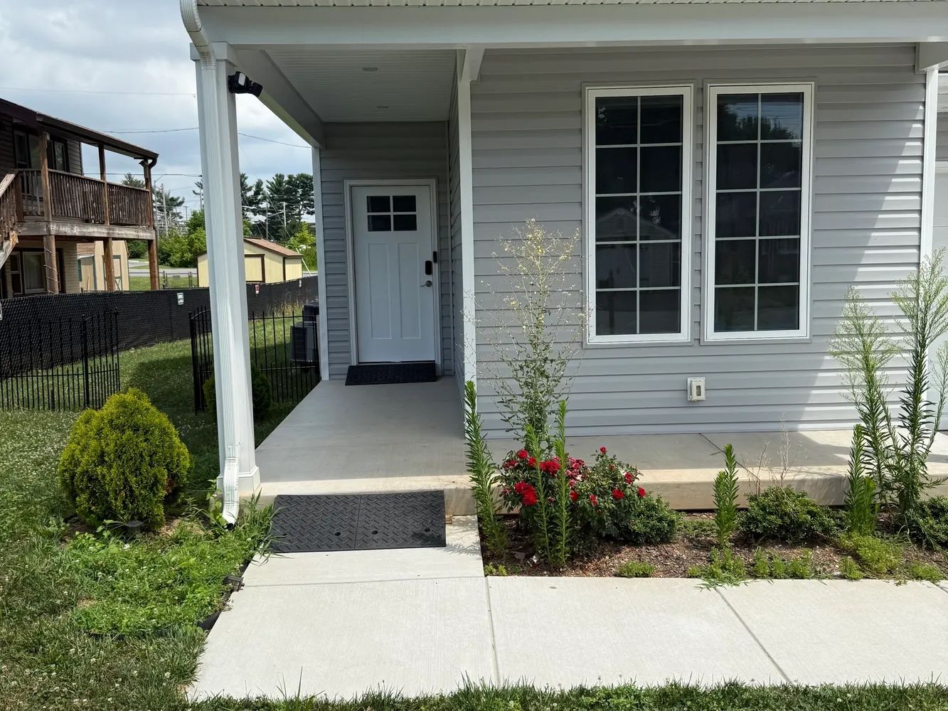 Front exterior of a building with a porch and landscaping