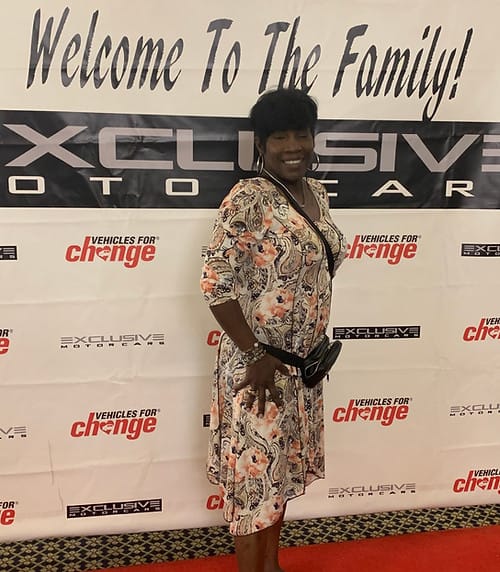 Uhh Wee, We Care, Inc, assisted living in Baltimore, MD — Woman posing at a welcome event backdrop
