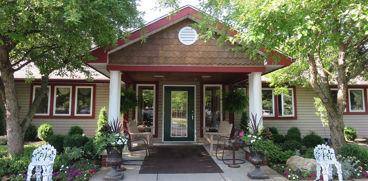 Front entrance of Heritage Manor with seating and flowers