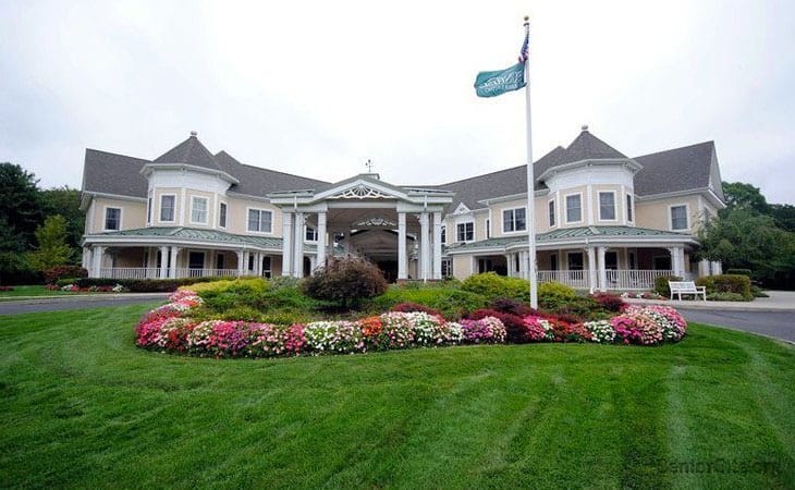 Well-maintained building exterior with flowers and flag